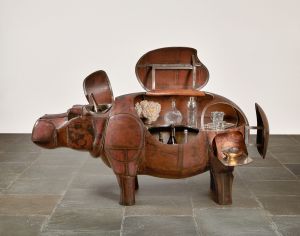 A bar cart shaped like a hippo, with several panels open to reveal the compartments holding bottles and glassware