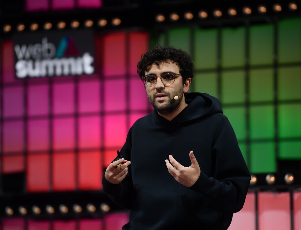 Man in black hoodie stands onstage