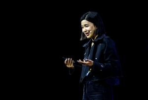 Woman in black jacket stands onstage